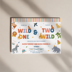A colorful children's birthday invitation card featuring safari animal illustrations and the text 'WILD & TWO WILD ONE' on a white background, photographed on a warm beige surface with soft diagonal shadows.